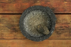 Empty stone mortar with pestle on wooden table, top view