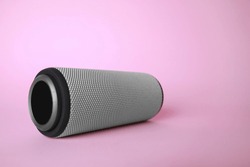 One portable bluetooth speaker on pink background, space for text. Audio equipment