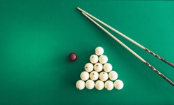 Russian billiard balls, cue, triangle, chalk on a table Green cloth Top view Copy space