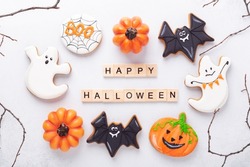 Set of various gingerbread cookies and Happy Halloween wooden blocks on white background. Bright homemade cookies for Halloween party