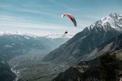 sporty tandem paraglider flying in the mountains of South Tyrol, Italy, Meran