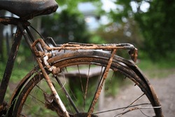 completely rusted bike parked at the side of the road. unusable grungy look.