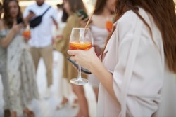 The girl is holding a glass with a cocktail. A party.