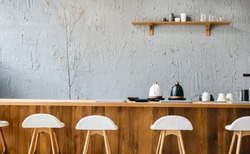 Seat and wooden counter with coffee equipment and wooden shelf on rough cement wall. design for cafe or home