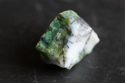 Uncut and raw chrysoprase stone on gray slate background