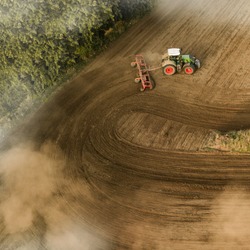 Farmer ploughing field on a late afternoon in Germany.