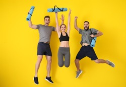 Young sporty people jumping against color background