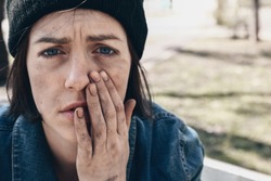 Portrait of sad homeless woman outdoors