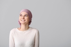 Optimistic woman after chemotherapy on light background