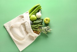 Eco bag with products on color background