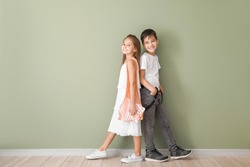 Cute fashionable children near color wall