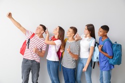 Cool teenagers taking selfie on white background