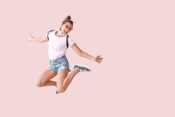 Jumping woman with headphones on color background