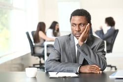 Lonely African-American businessman in office. Stop racism