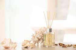 Reed diffuser and sea shells on table in room