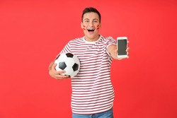 Happy man with soccer ball and mobile phone on color background. Concept of sports bet