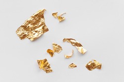 Pieces of golden foil on white background