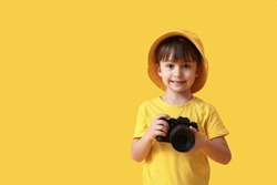 Cute little photographer on color background
