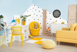 Stylish interior of modern children's room with wooden stadiometer
