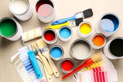 Composition with cans of paints, palette samples and tools on light background