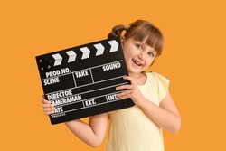 Little girl with movie clapper on color background