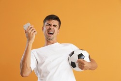 Happy man with cellphone and ball after winning of his sports bet on color background