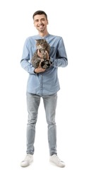 Young man with cute cat on white background