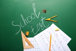 Answer sheets with stationery and text SCHOOL TEST on blackboard