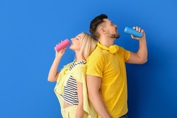 Couple drinking soda on color background