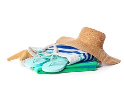 Bag with beach accessories and flip-flops on white background