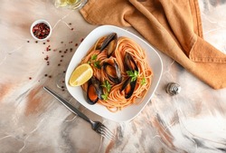 Plate of tasty Mussels Marinara with spaghetti on grunge background