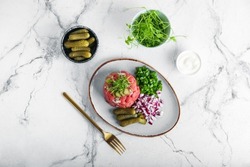 Plate with tasty beef tartare on light background