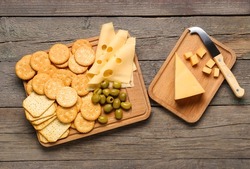Crunchy crackers and cheese on wooden background