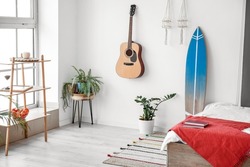 Interior of modern stylish bedroom with surfboard