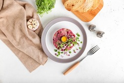 Plate with tasty beef tartare on light background