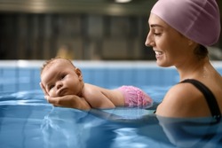 Cute baby with mother in swimming pool
