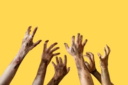 Hands of zombies on color background