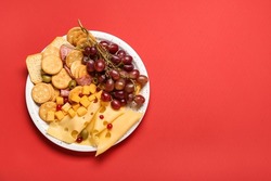 Platter with crunchy crackers and cheese on color background
