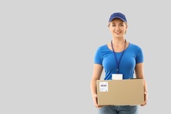 Female courier with parcel on light background