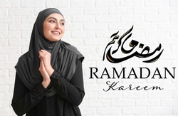 Young Muslim woman on white brick background. Ramadan celebration