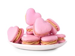 Plate with tasty heart-shaped macaroons on white background