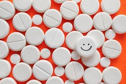 One pill with drawn happy face among ones on color background, closeup