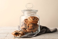 Glass jar with tasty homemade cookies on table