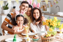 Happy family celebrating Easter at dining table in kitchen