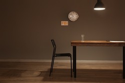 Table and chair in empty interrogation room