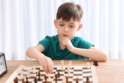 Little boy playing chess during tournament in club