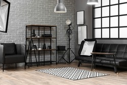 Interior of modern photo studio with shelving unit, couch and professional equipment