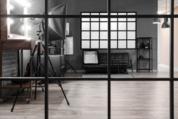 Interior of modern photo studio with couch and professional equipment