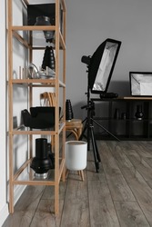 Shelf unit with different professional equipment in stylish photo studio