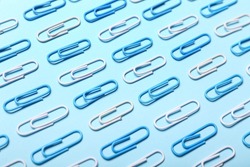 Blue and white paper clips on color background